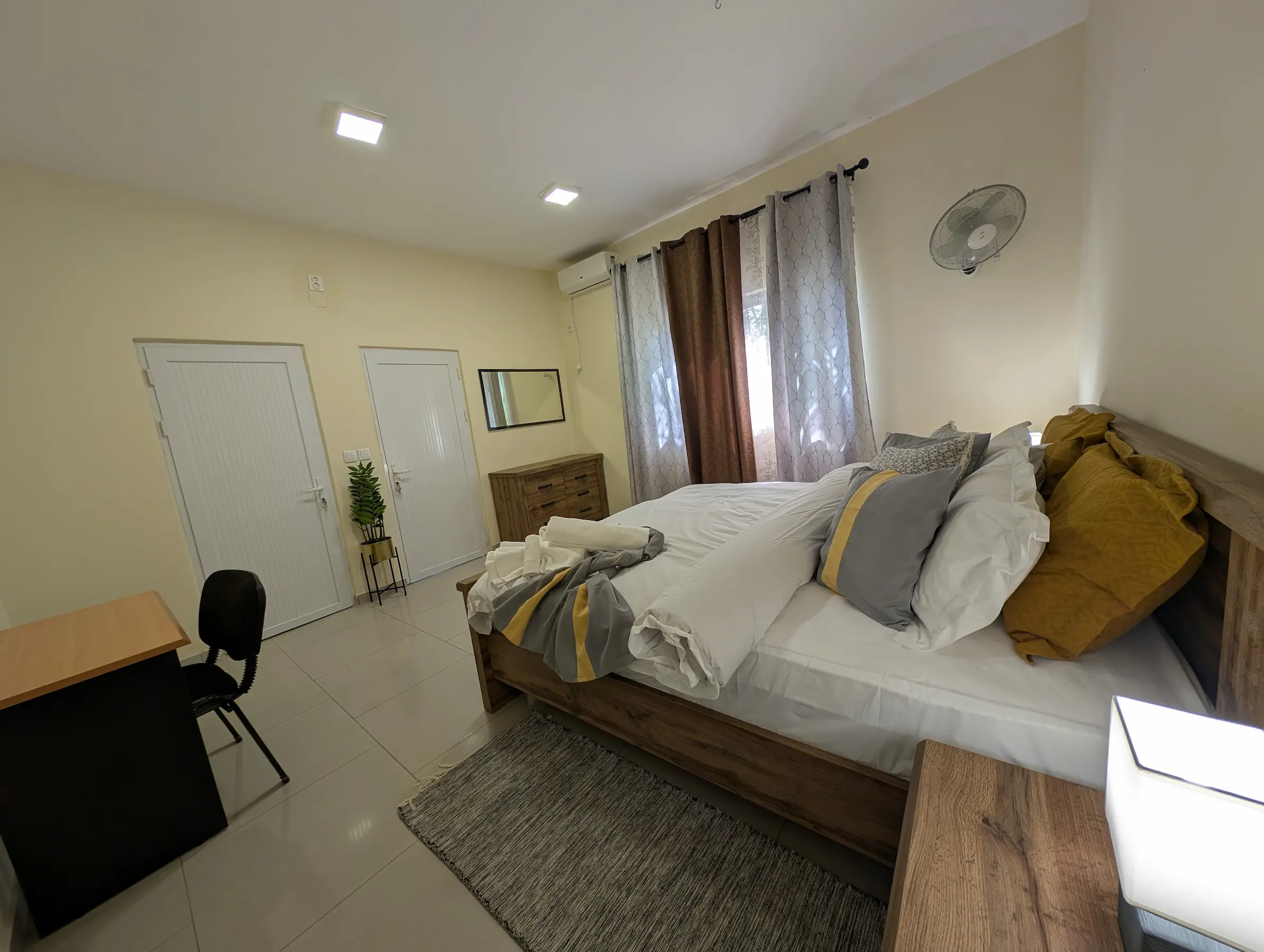 Bedroom with wooden bed and brown curtains.