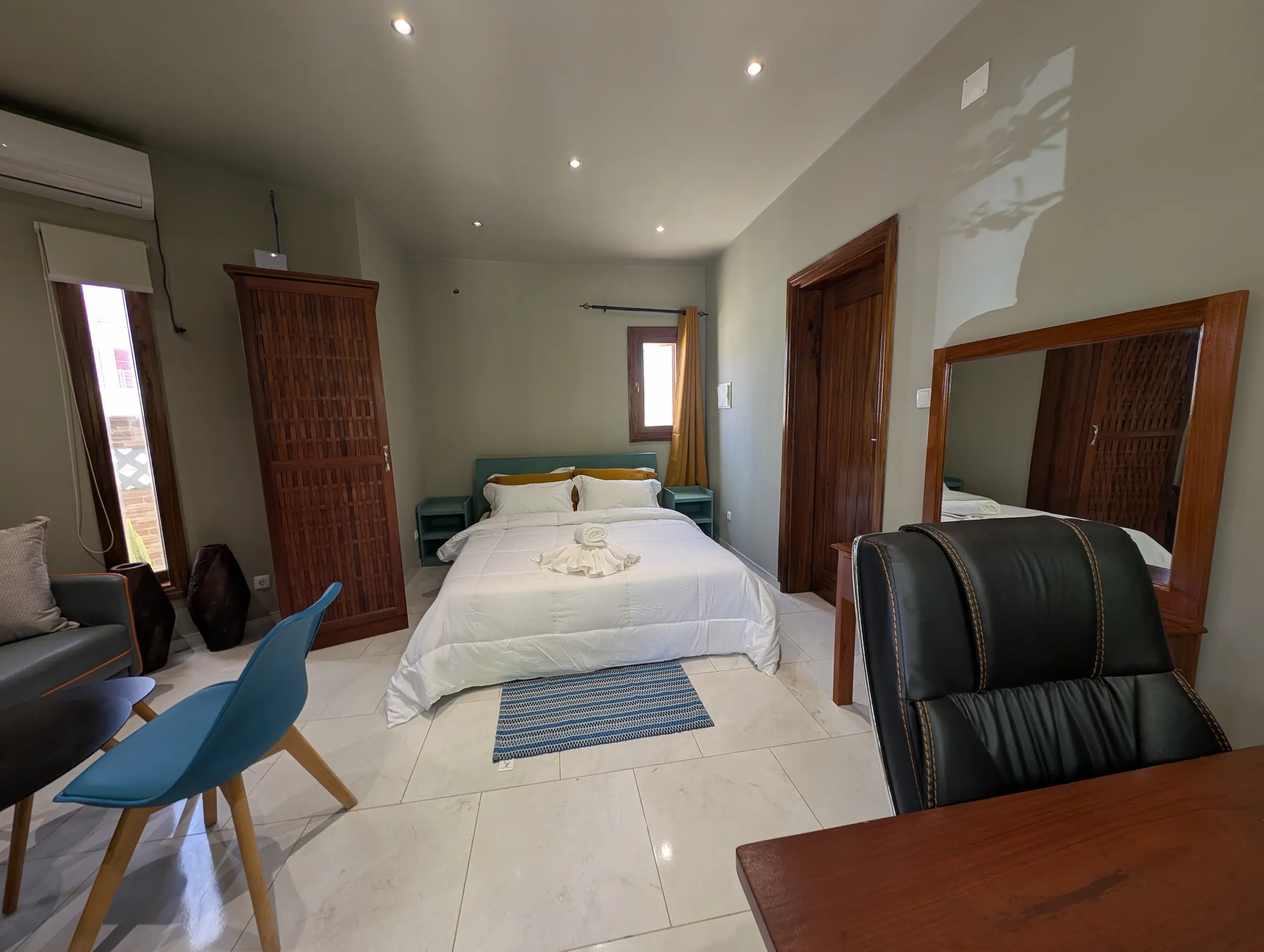 Bedroom with a neatly made bed and cozy seating area.